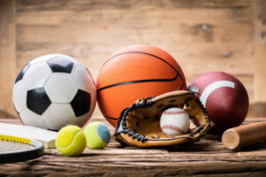 High Angle View Of Various Sport Accessories On Textured Wooden Surface