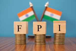 Concept of FPI or foreign portfolio investment on India in wooden block letters on stack of coins with Indian Flag as a background.