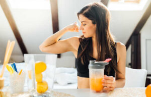 Woman,At,Home,Drinking,Orange,Flavored,Amino,Acid,Vitamin,Powder.keto