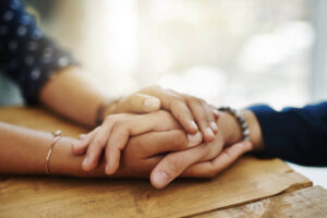 Closeup shot of two unrecognizable people holding hands in comfort